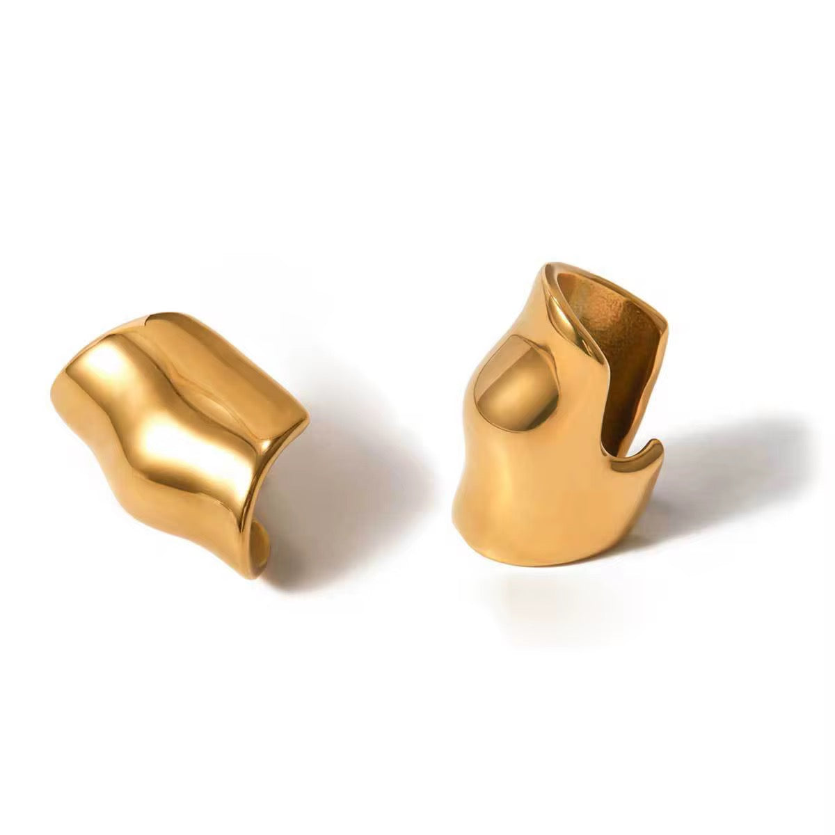 Pair of gold cuff earrings on a white background
